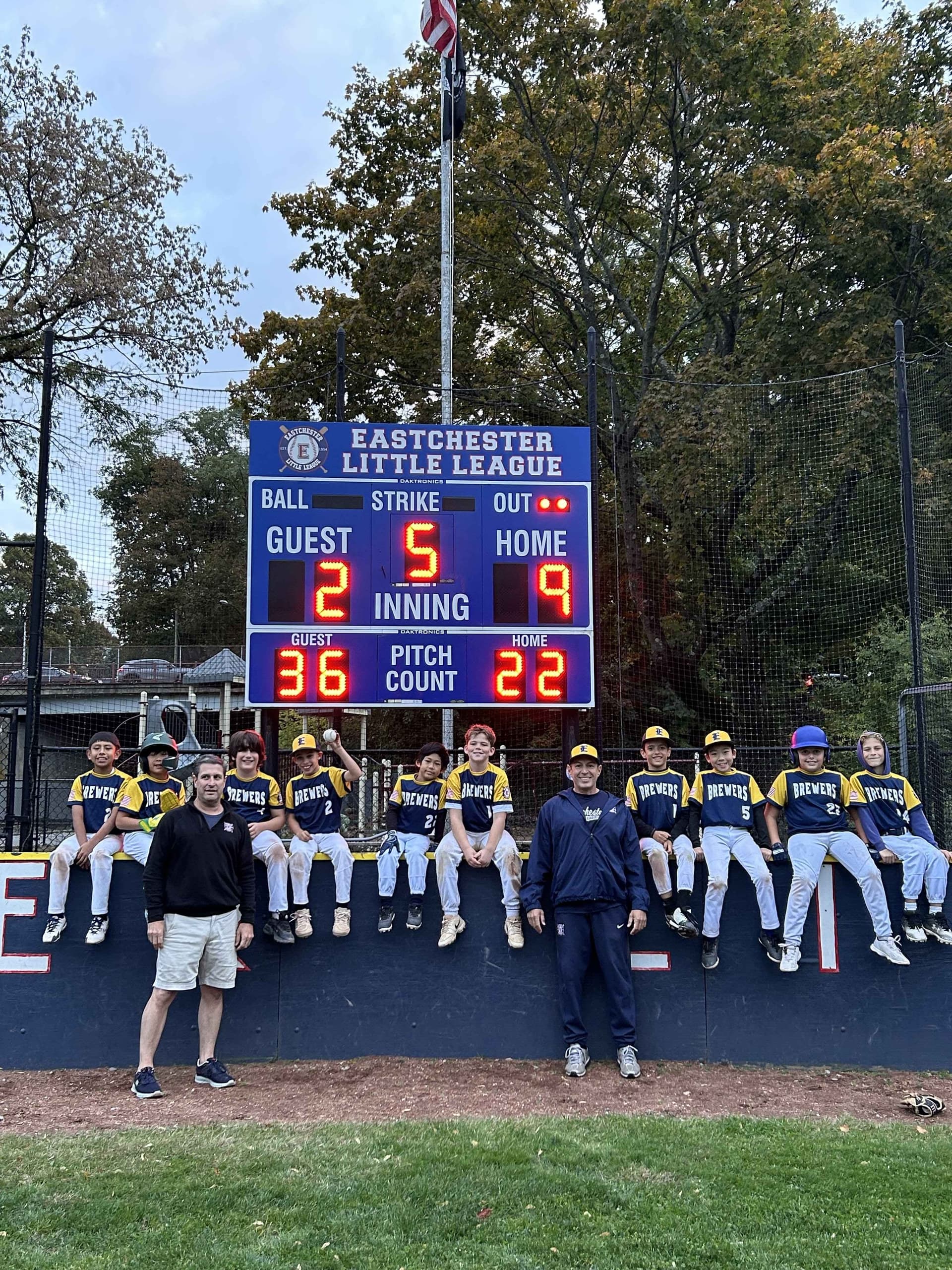 Brewers Little League team celebrating baseball win with Biagio Maffettone